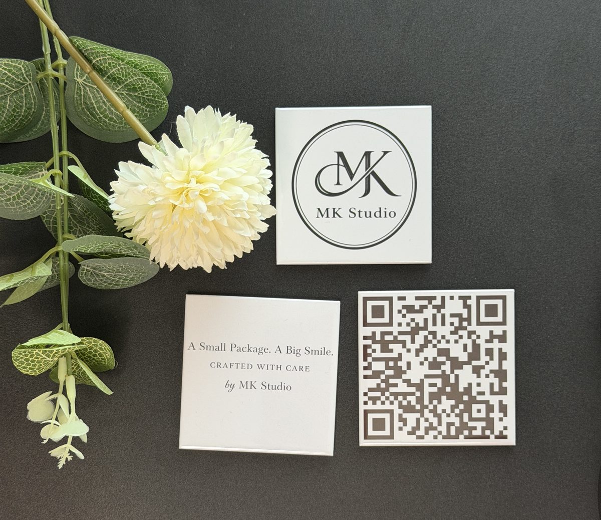 MK Studio logo magnet beside a care card and review QR